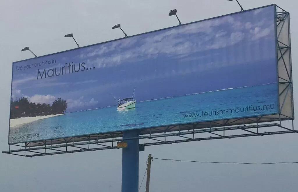 The bottom left corner of this 2014 billboard on the Kanda Highway reads "No visa required." 