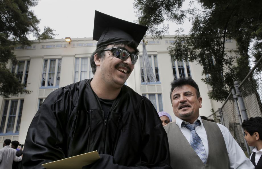 Saleh Khalaf and father Raheem smile after Wednesday’s graduation ceremonies in Oakland.